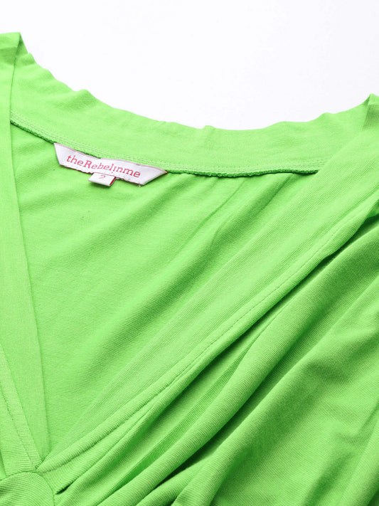 Close-up of a bright green top with a brand label on a white background