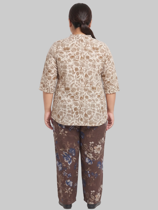 Person wearing a beige floral top and brown floral pants on a white background