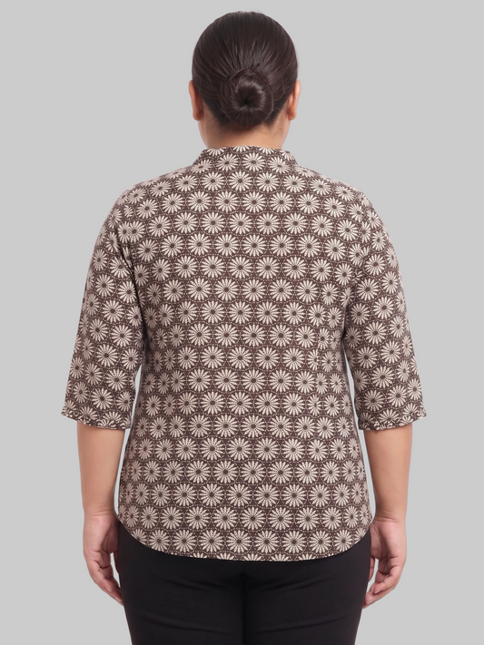 Person wearing a brown floral patterned shirt on a white background