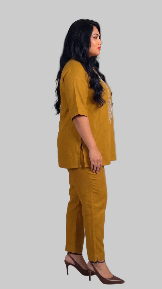 Woman wearing a mustard yellow outfit against a gray background