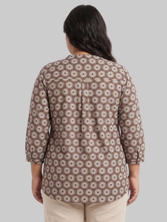 Woman wearing a brown floral patterned shirt on a white background