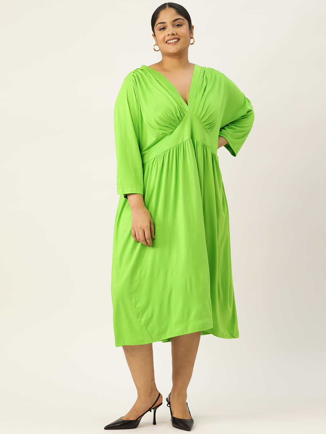 Woman wearing a bright green dress on a white background