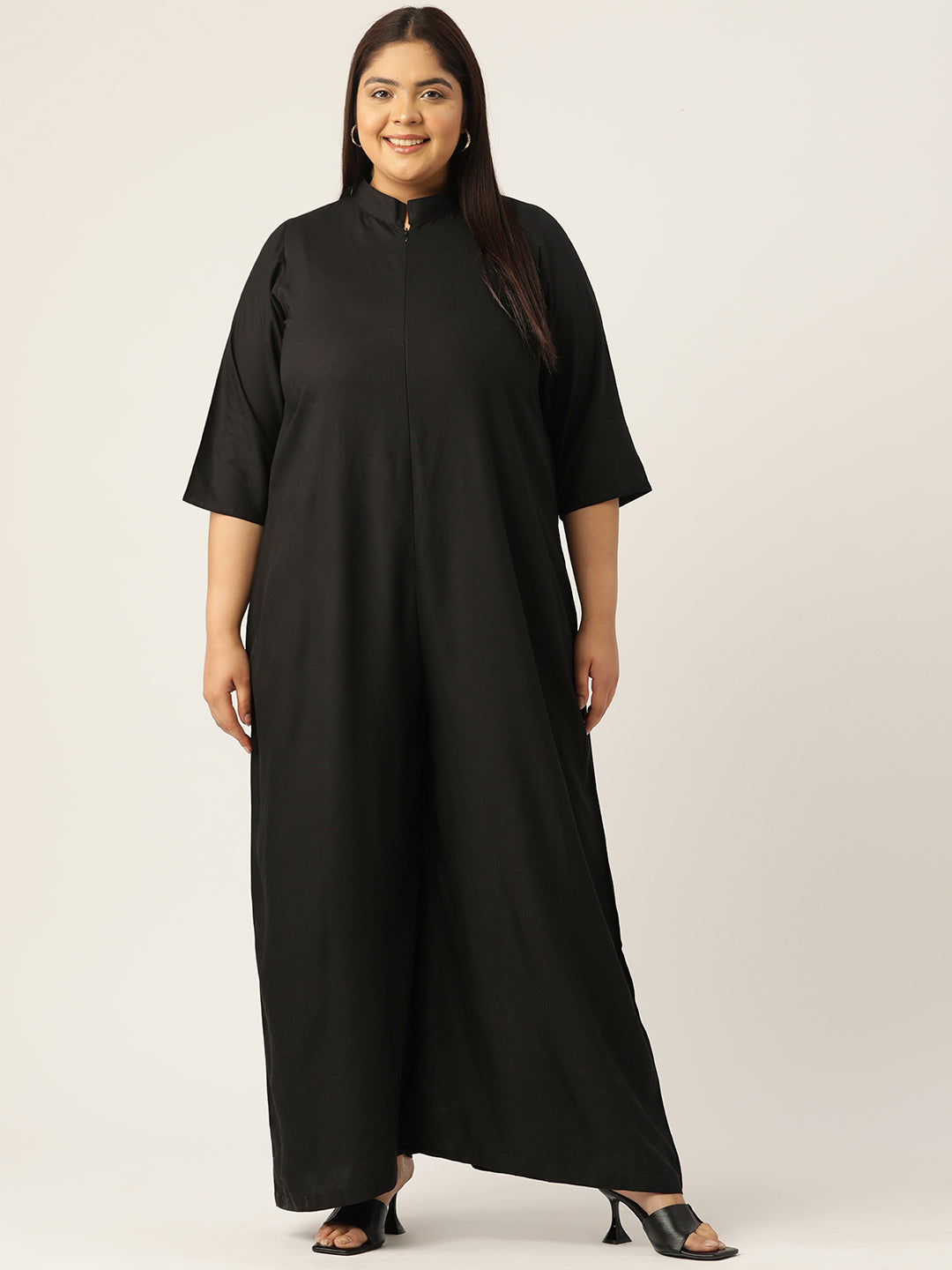 Woman wearing a black dress against a plain background