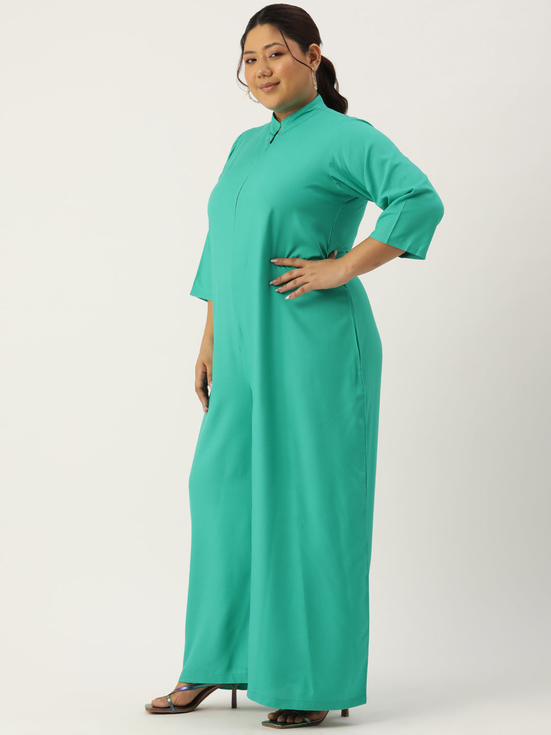 Woman wearing a teal dress on a white background
