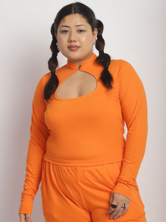 Woman wearing an orange outfit with a cut-out design on a plain background