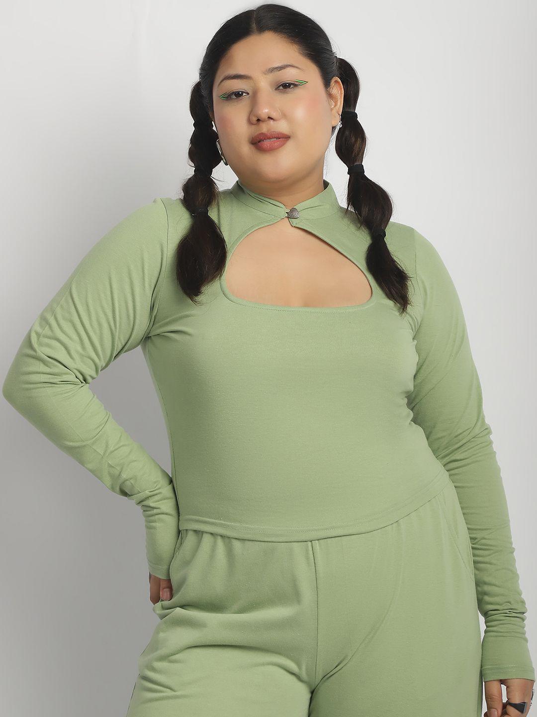 Woman wearing a green long-sleeve top and pants set against a white background