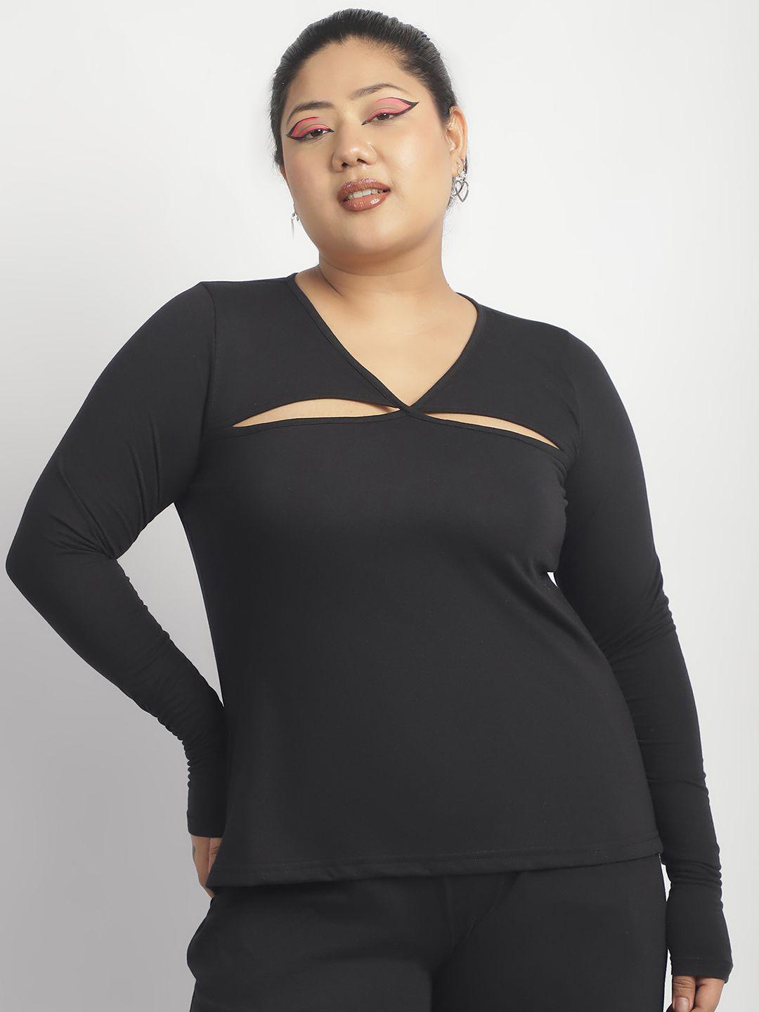 Person wearing a black long-sleeve top with cut-out design on a plain background